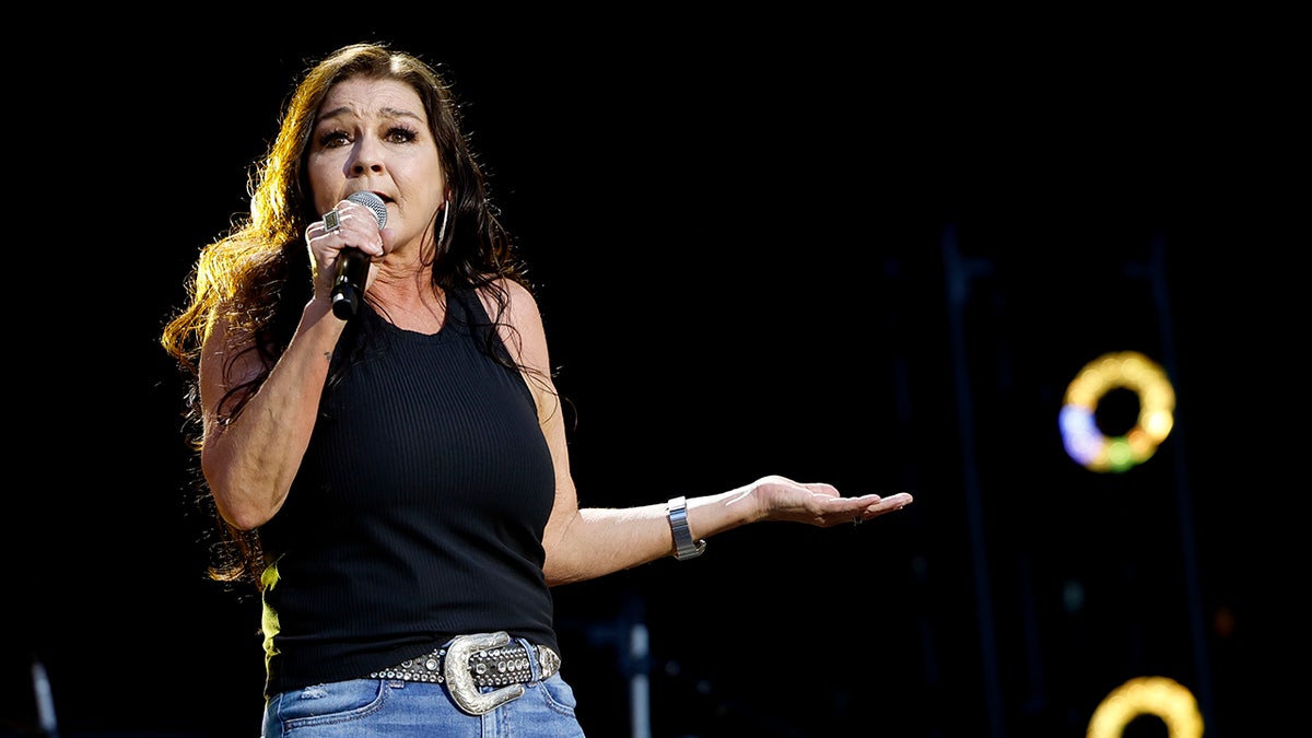 Gretchen Wilson canta no palco com uma blusa preta e jeans