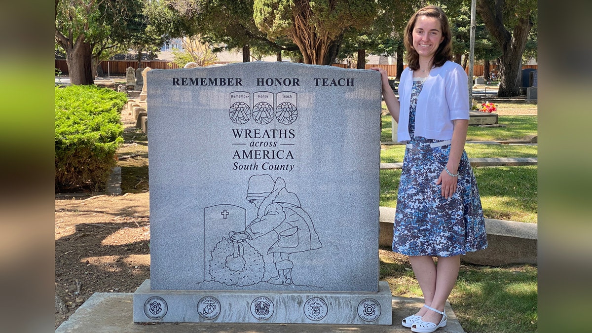 Mujer junto al monumento Wreaths Across America.