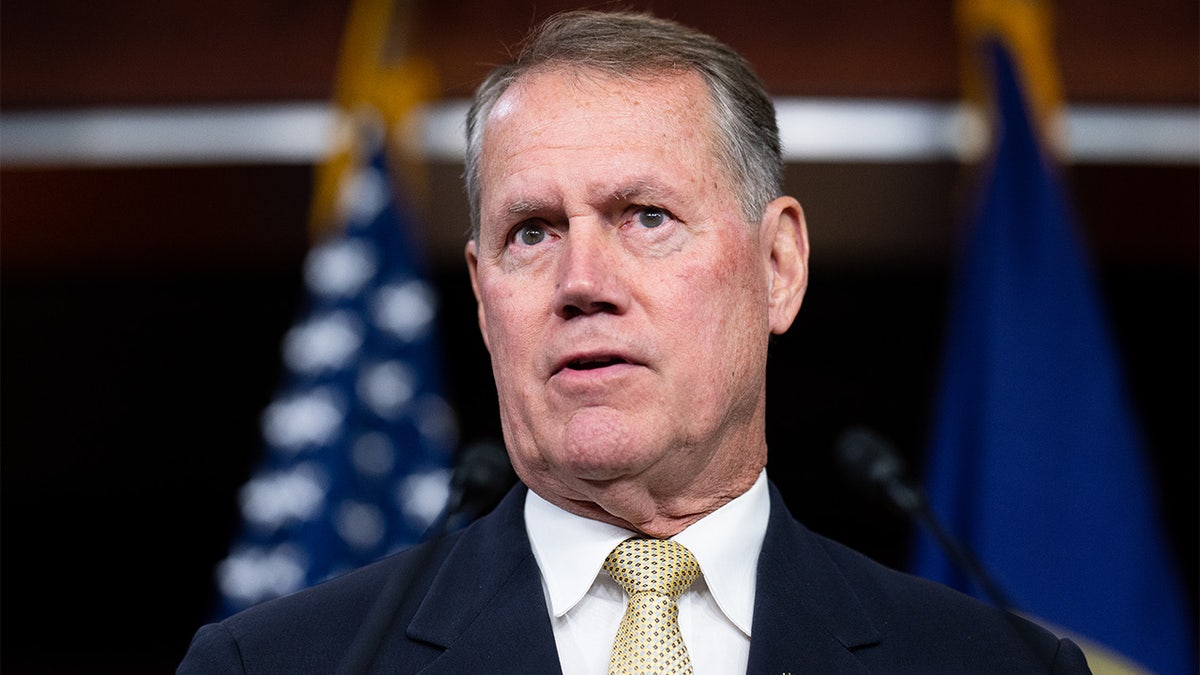 A White middle aged man at a press conference