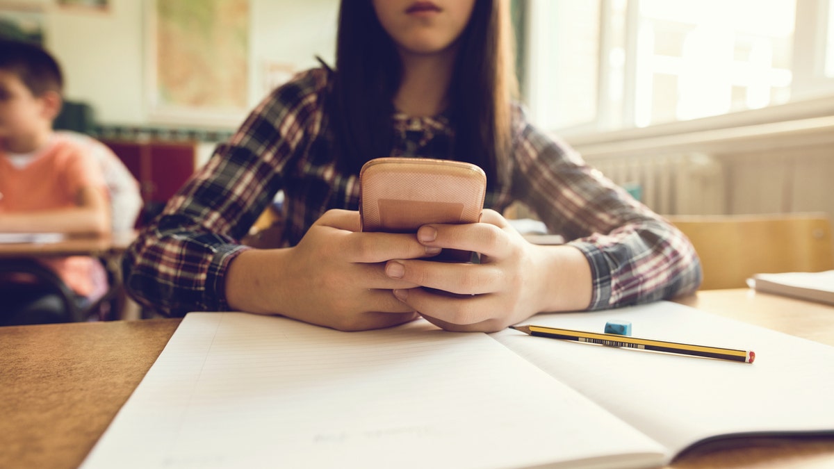 Girl using phone in school