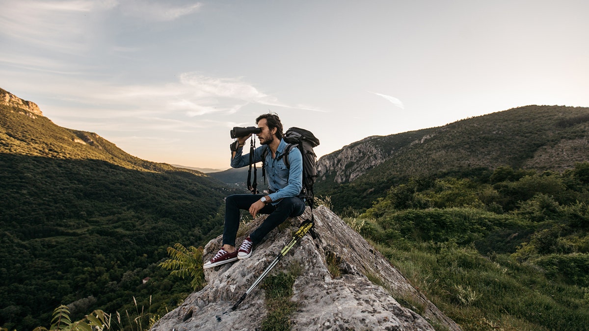 Wanderer blickt durch ein Fernglas