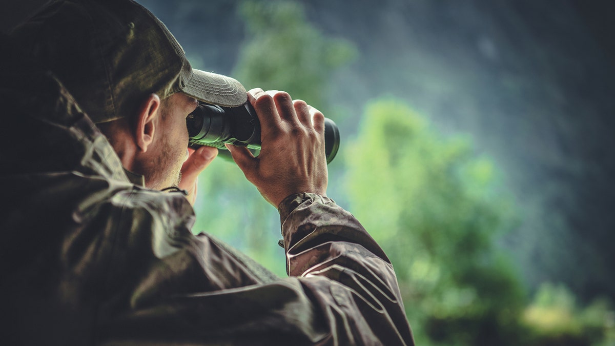 hunter looking through binoculars