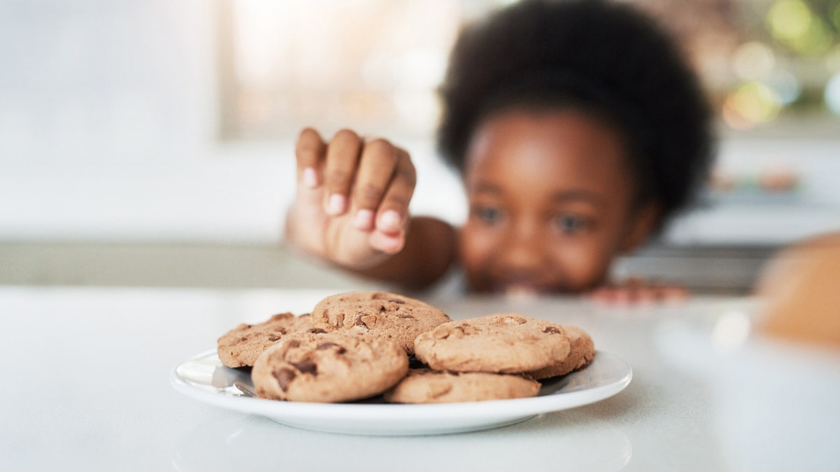 niña robando galletas en casa