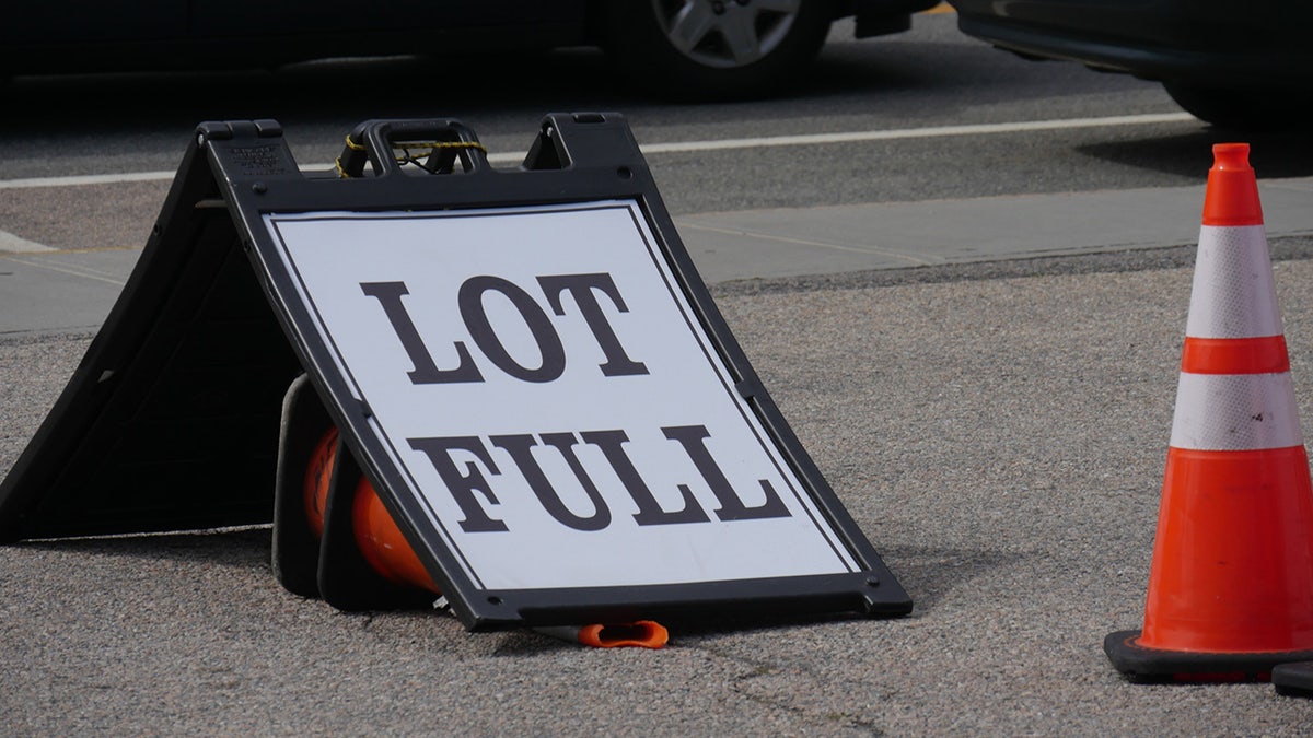 A "Lot Full" sign next to a cone.