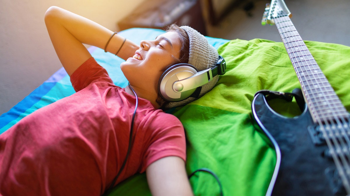 chico preadolescente escuchando música en su habitación