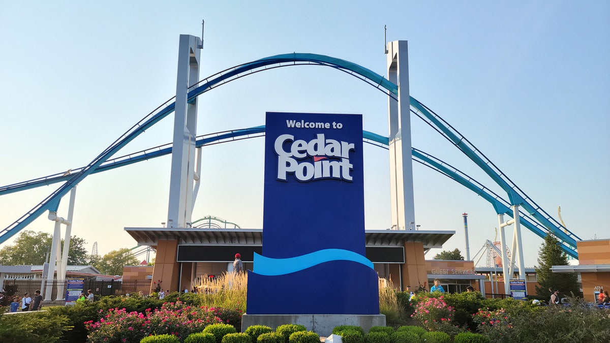 Tanda Cedar Point dengan roller coaster di latar belakang.