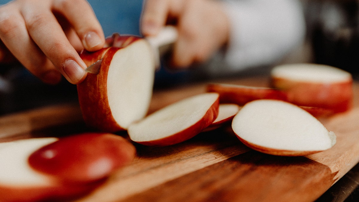 Mujer joven cortando manzanas