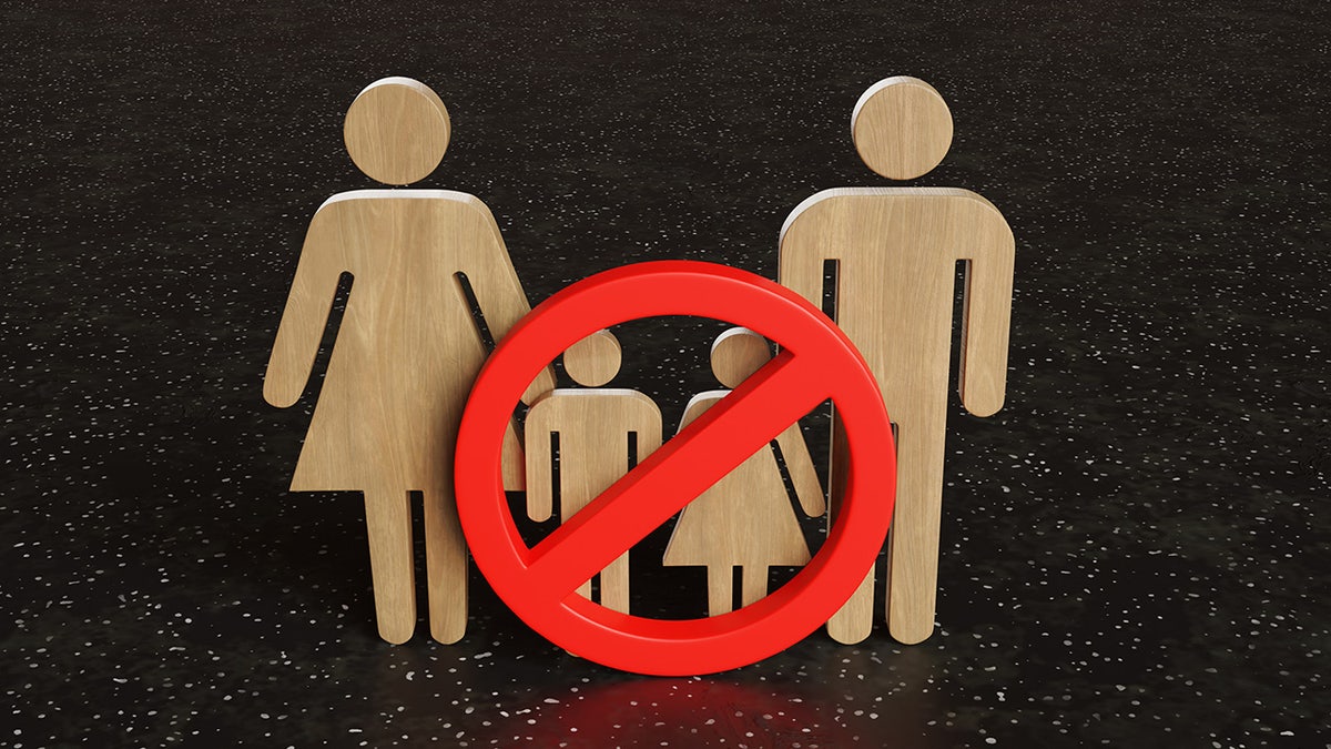 Image of a man and woman symbol with an ex above two smaller men and women symbols in the middle, which are meant to represent "childfree."