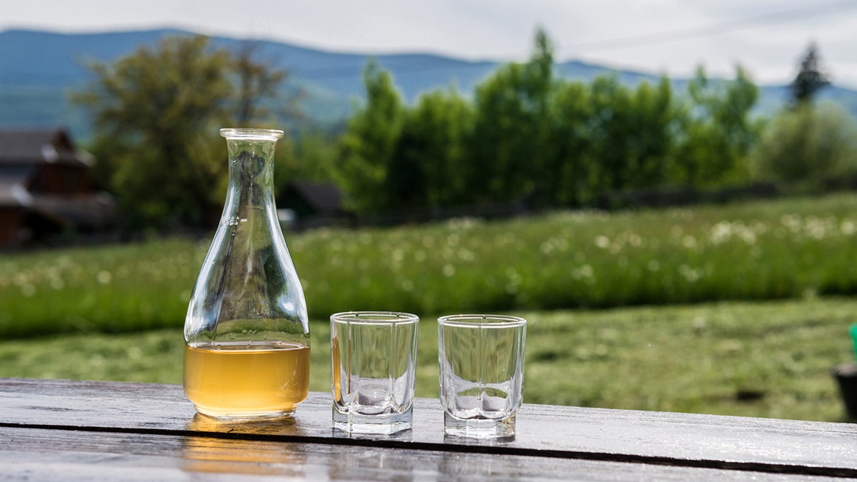 Dulce hidromiel de vino de miel amarilla en un hermoso paisaje de montaña. Listo para beber