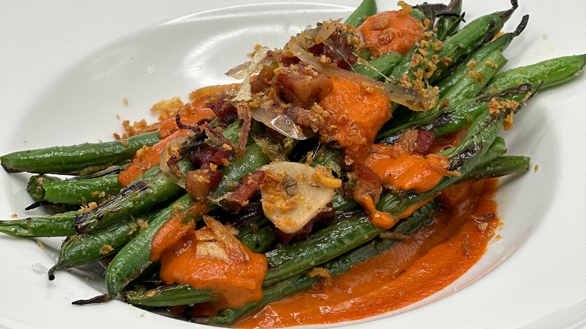 Un plato de judías verdes cocinado con un puré.