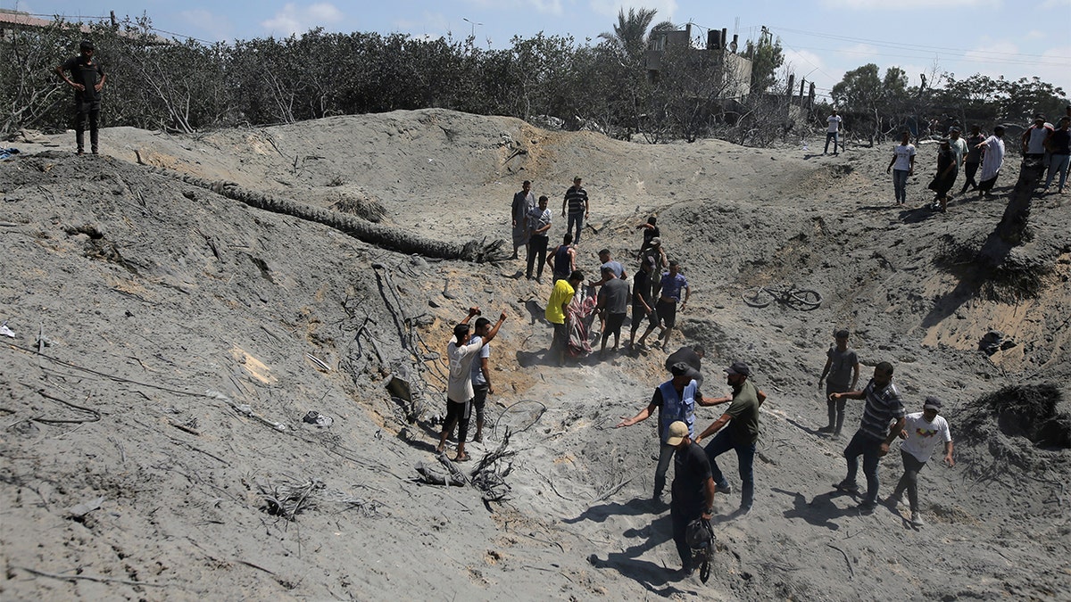 Palestinos buscando entre los escombros