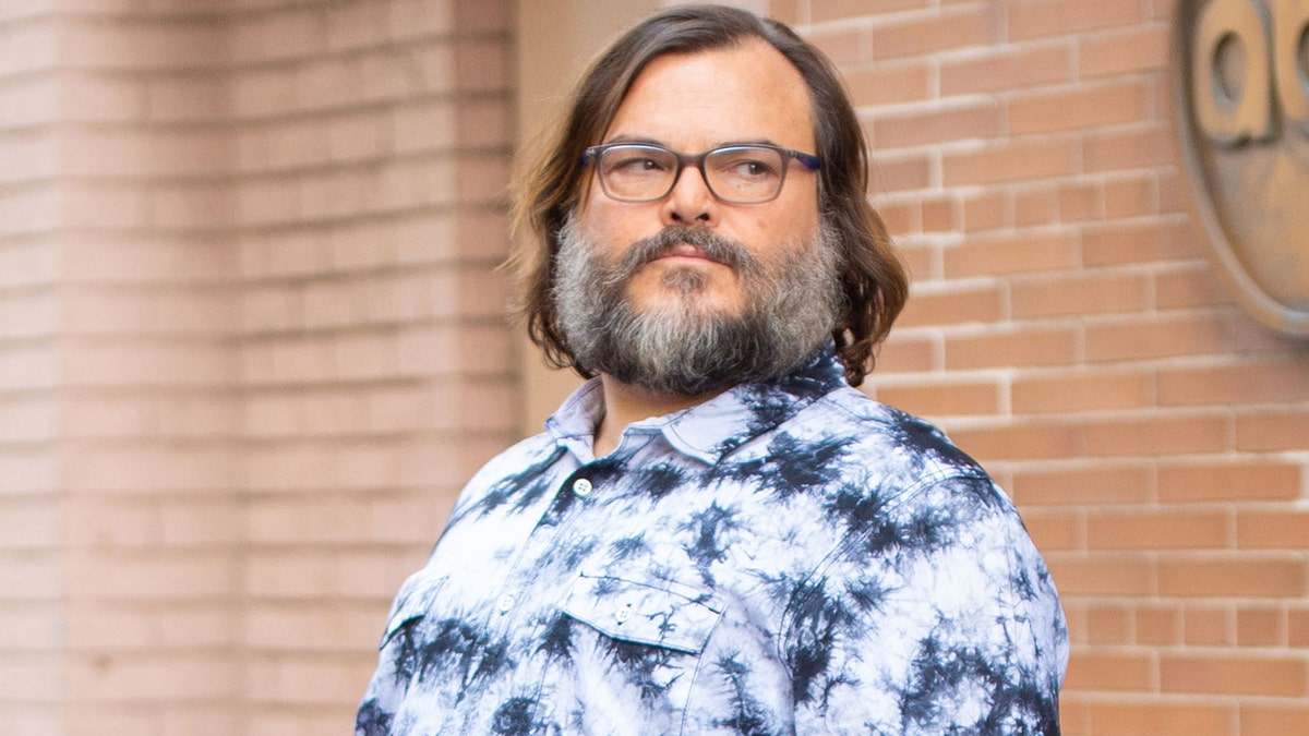 Jack Black leaving The View in a blue and white shirt.