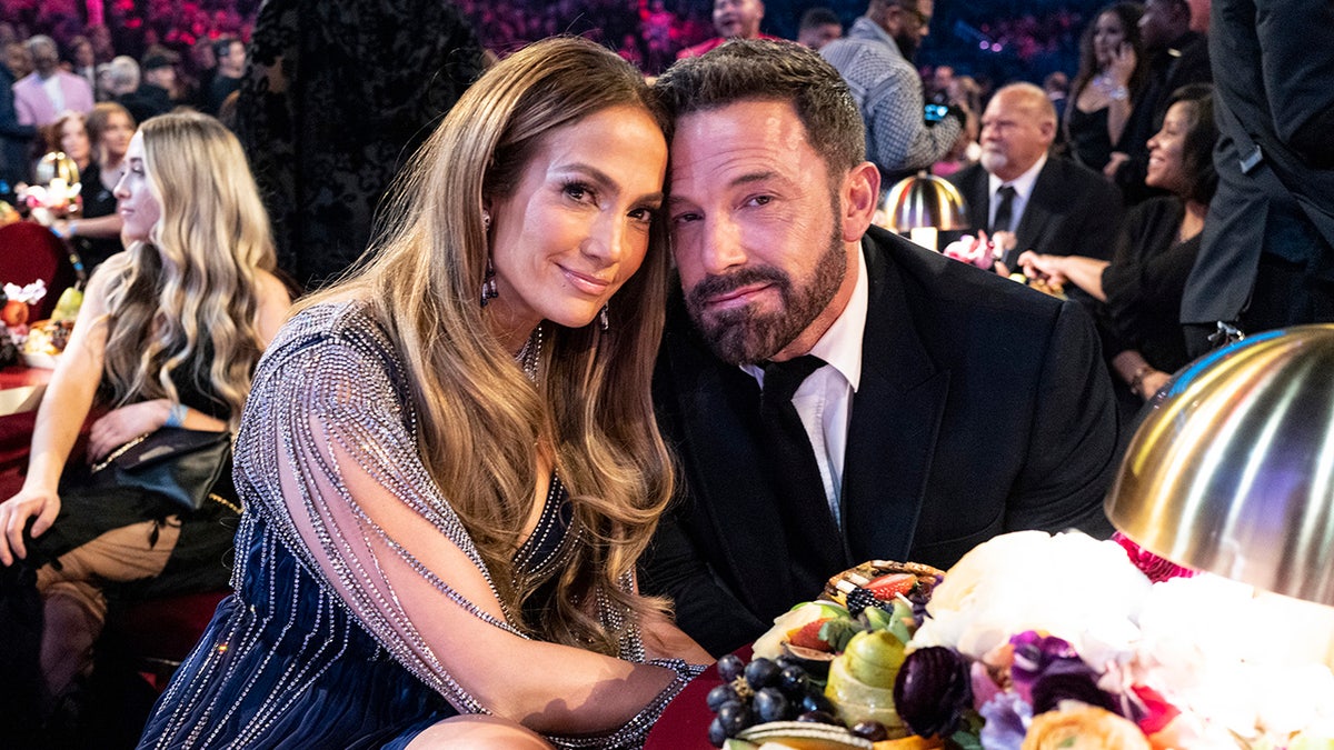 Jennifer Garner in a sequined dress smiles softly with husband Ben Affleck in a classic tuxedo, also smiling softly at the Grammys