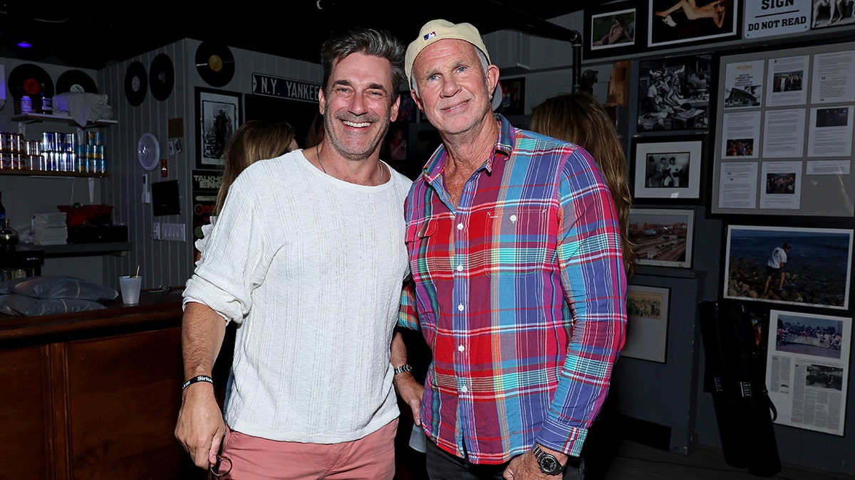 L'acteur Jon Hamm sourit à côté de Chad Smith dans les Hamptons