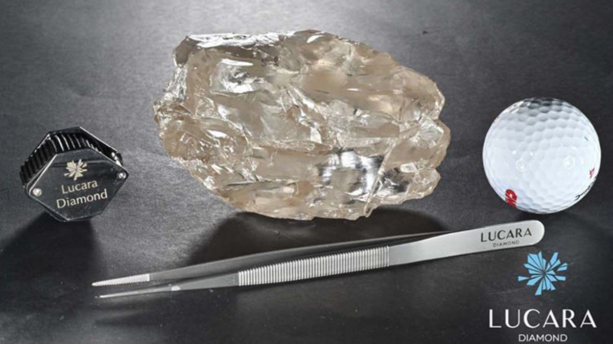 2,492-carat diamond next to tweezers and golf ball