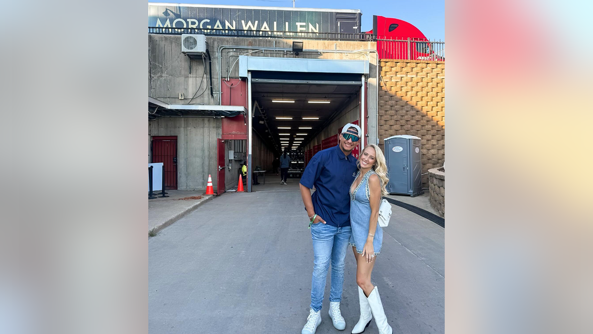 Patrick Mahomes in a blue shirt and jeans poses with his wife Brittany in a demin dress at the Morgan Wallen concert