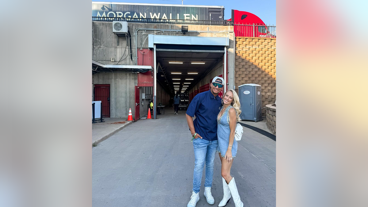 Patrick Mahomes con camisa azul y vaqueros posa con su mujer Brittany con un vestido demin en el concierto de Morgan Wallen