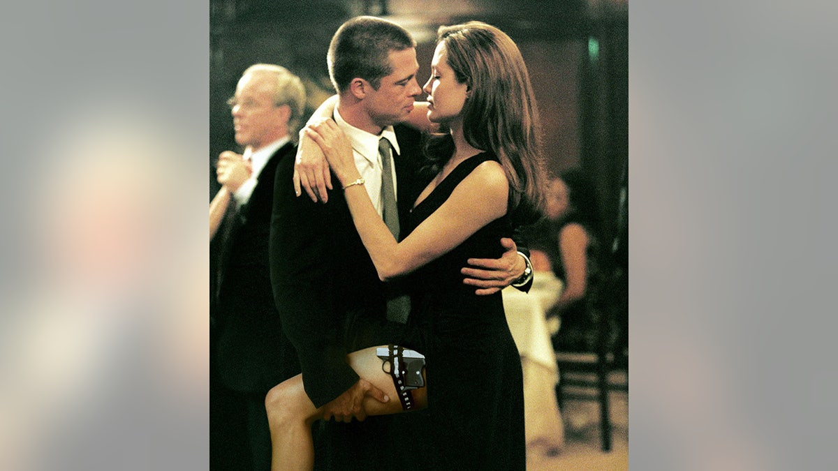 Brad Pitt in a suit holds Angelina Jolie by the leg in a steamy scene from "Mr. and Mrs. Smith"