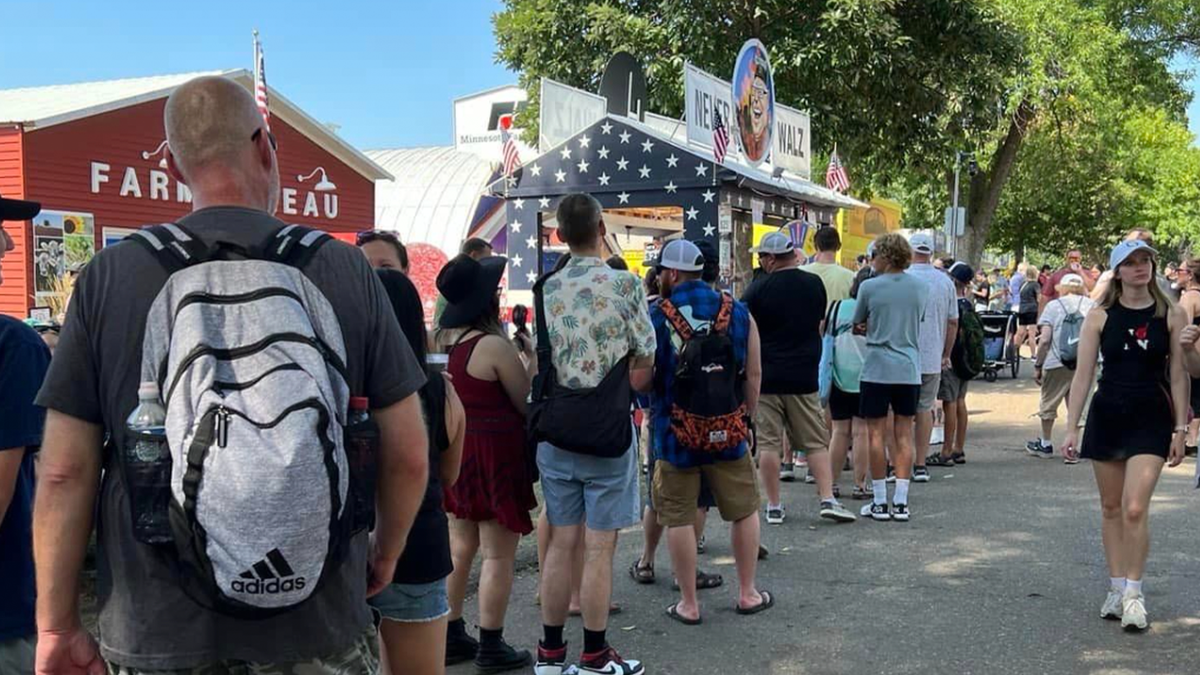 Multitud esperando en la caseta "Nunca Walz" de la feria estatal de Minnesota