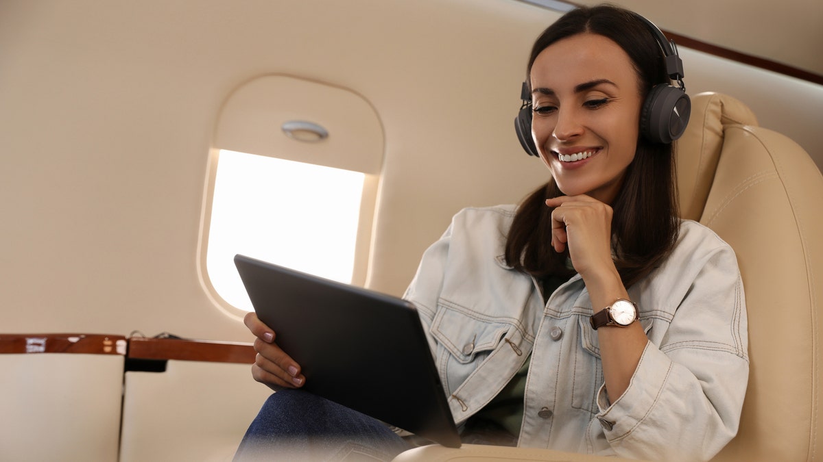 A woman watching a movie on an airplane