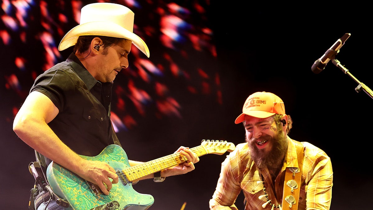 Post Malone smiles during concert with Brad Paisley.