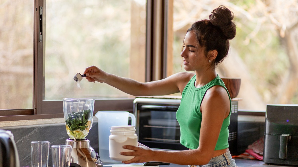 Woman preparing a protein shake