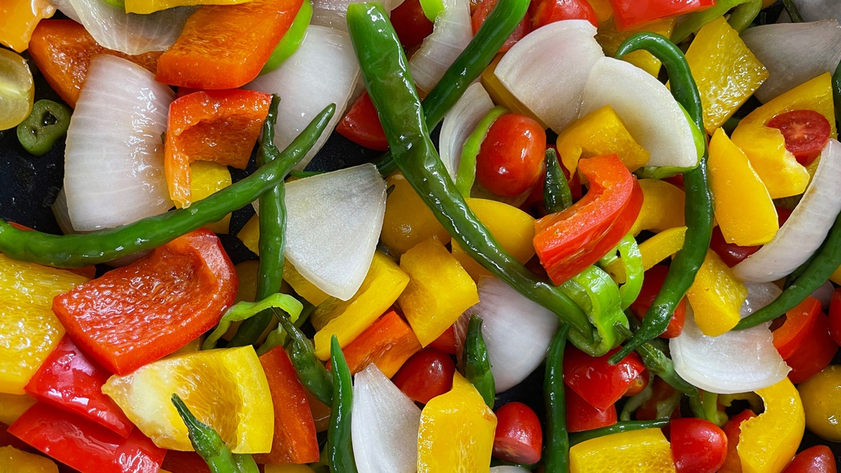 Este es un primer plano de las distintas verduras que componen los colores del arco iris en un plato salteado de verduras.