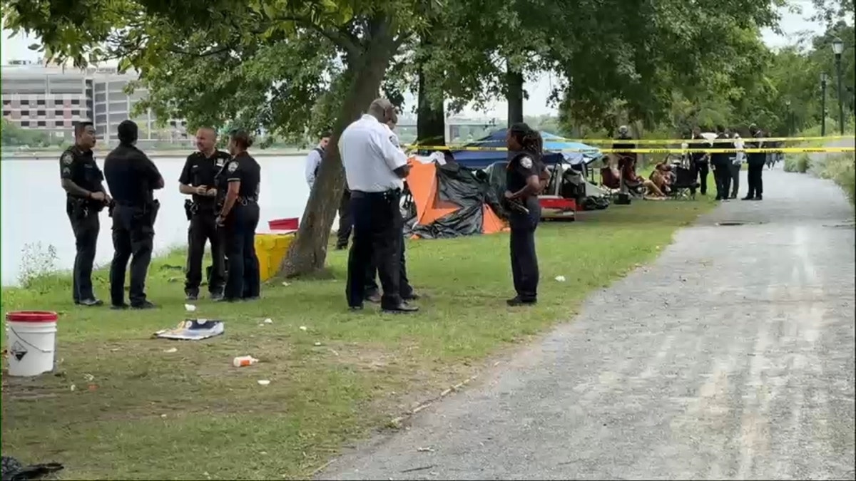 Officers stand by taped off tents on Randall's Island