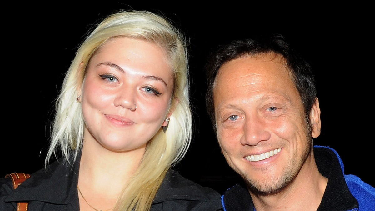 Rob Schneider and girl  Elle King smile.