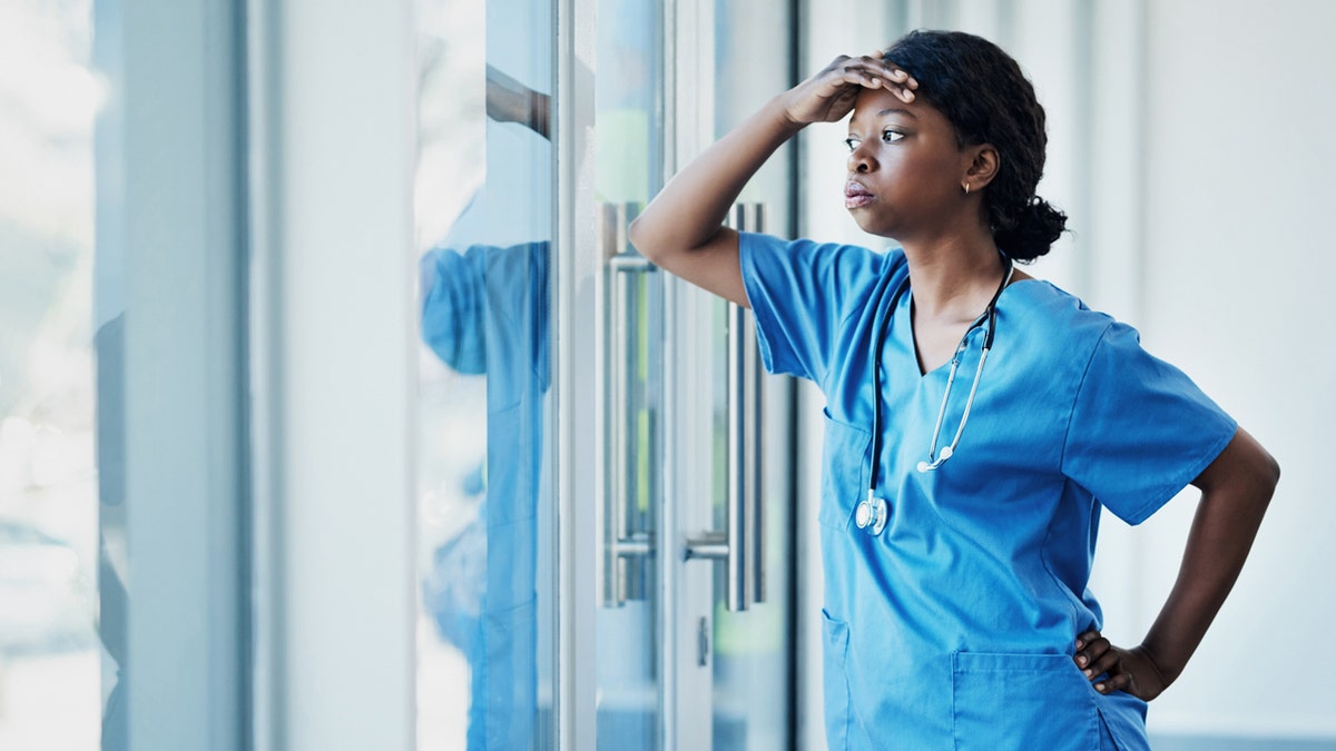 A stressed nurse looking out the window