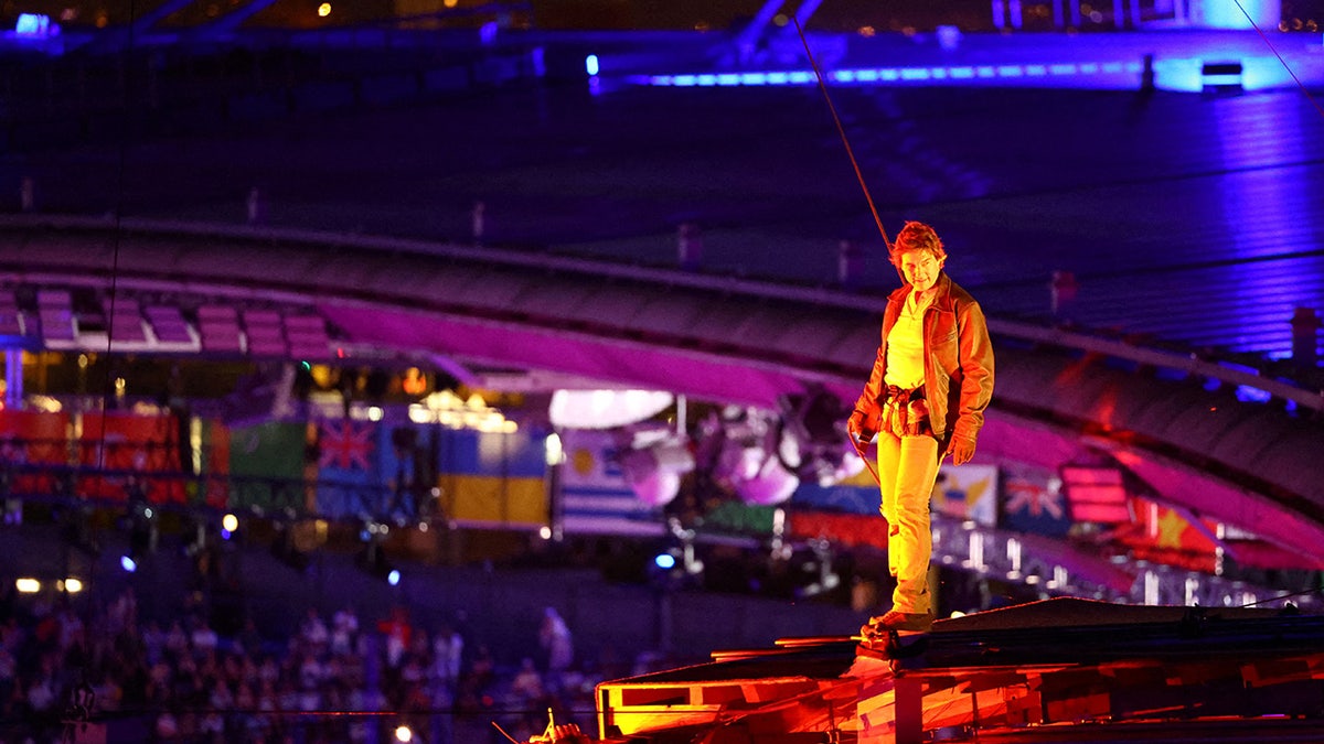 Tom Cruise zakłada uprząż do wielkiego skoku.