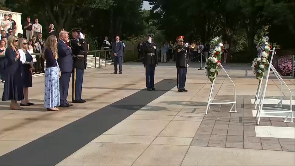 Trump puts his hand on his heart while music plays