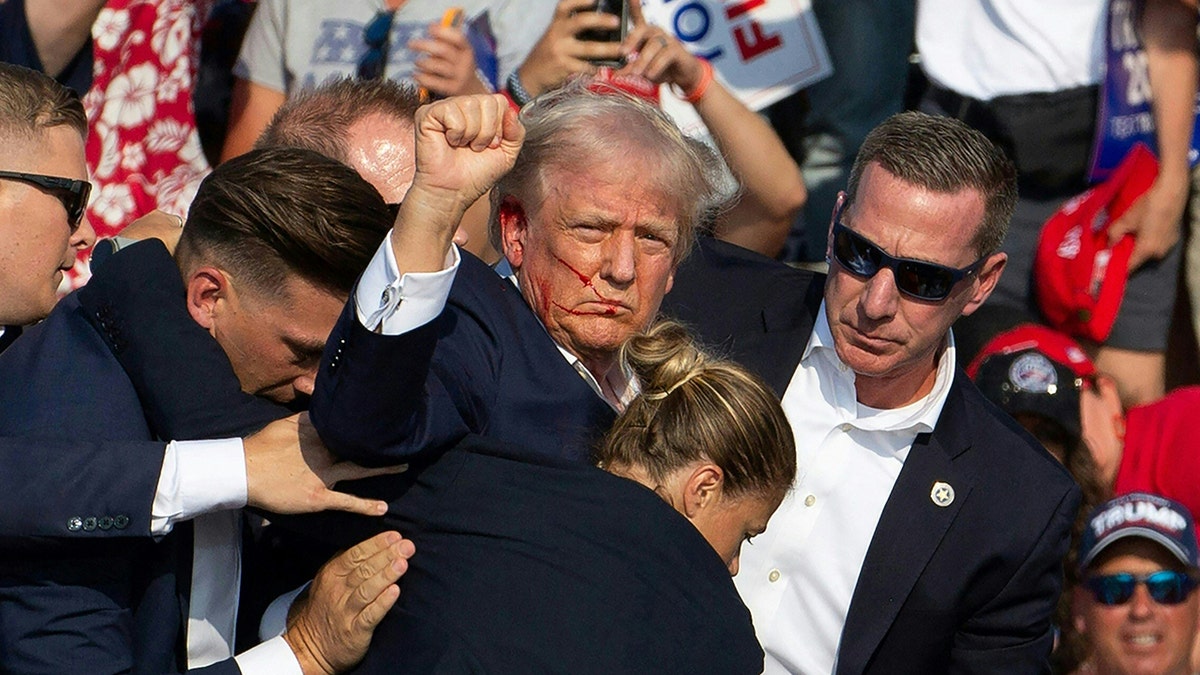 Trump with arm raised after first assassination attempt