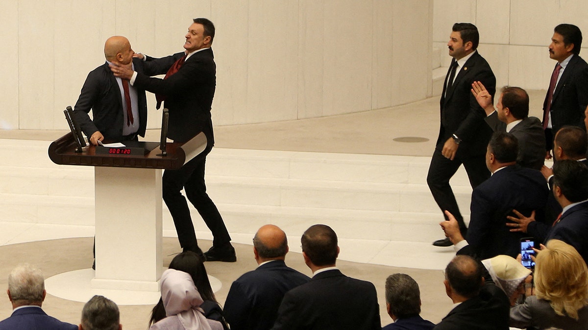 Turkish parliament member with his hands around another member's neck