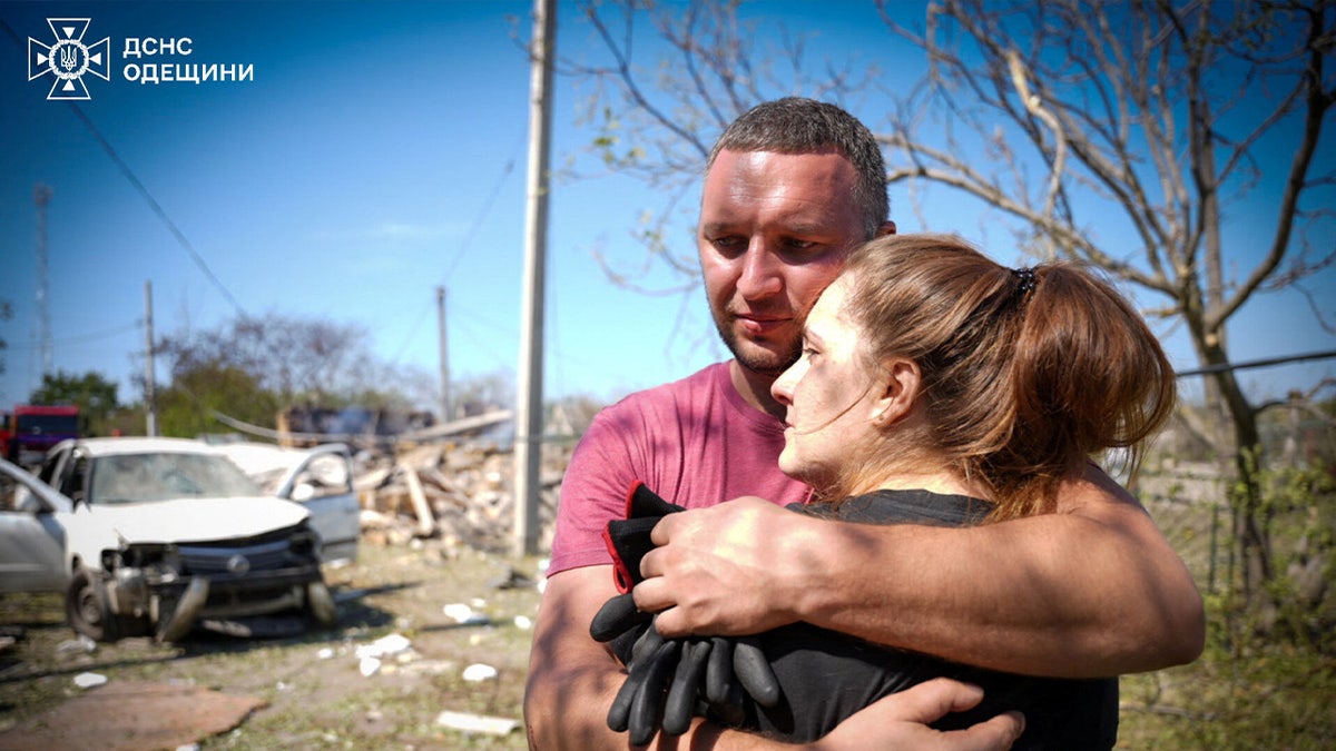 Local residents embrace each other at the site of a Russian missile strike, amid Russia's attack on Ukraine, in the Odesa region, on Aug. 26, 2024. 