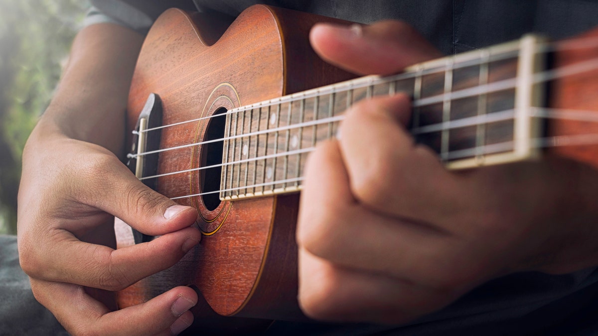 Close-up of person playing a ukulele