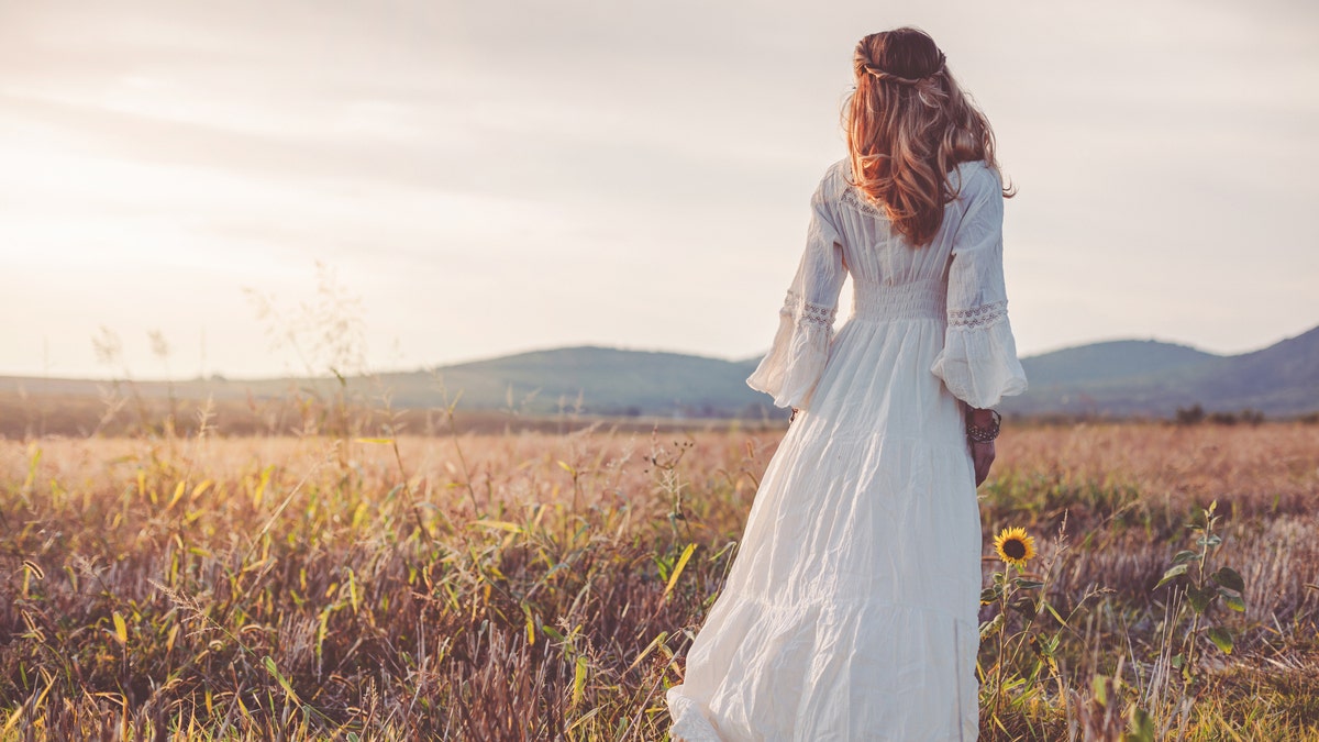 Woman wearing white dress in a field