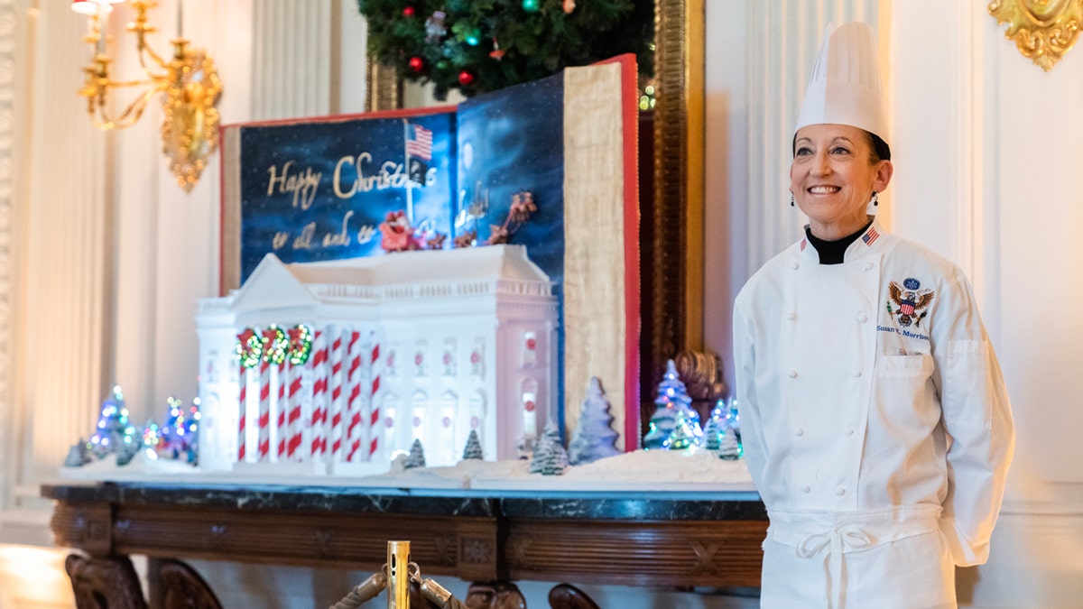 El chef pastelero ejecutivo de la Casa Blanca de pie junto a una casa de jengibre