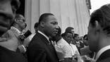 The Great March organized by A. Philip Randolph and Bayard Rustin united civil rights, religious, and labor organizations to peaceably advocate for economic and civil equality of African Americans.  Martin Luther King Jr. stands holding his speech to his chest as he interacts with reporters beside the Lincoln Memorial. (Photo by Bob Parent/Getty Images)