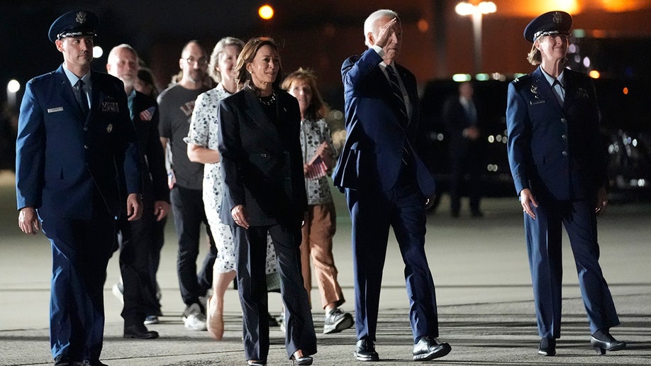 El presidente Joe Biden y la vicepresidenta Kamala Harris caminan para saludar al reportero Evan Gershkovich, Alsu Kurmasheva y Paul Whelan