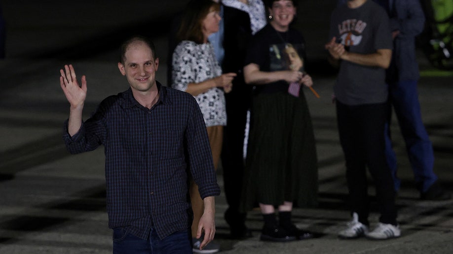 Evan Gershkovich gestures after disembarking from a plane