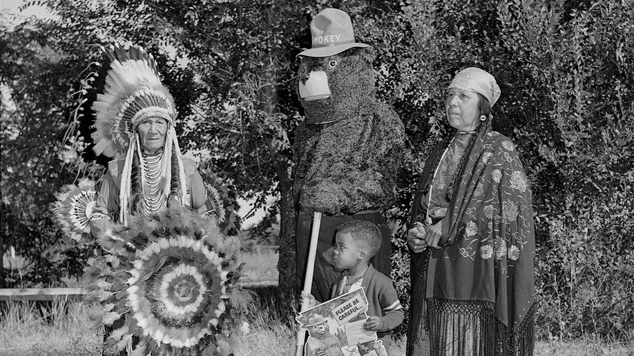 El Oso Smokey, el jefe Flathead (Salish) Paul Charlo, su esposa y el joven Allen Thompson posan.