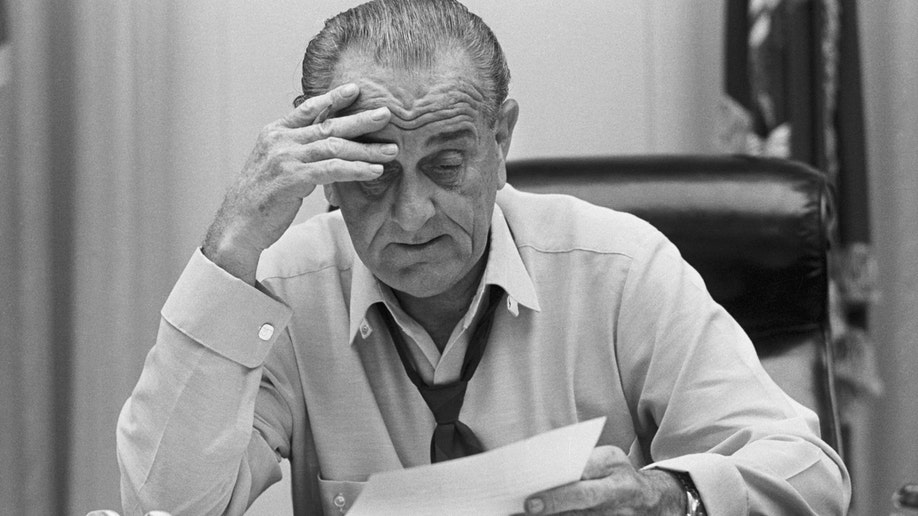 Lyndon B. Johnson with stressed look at his desk