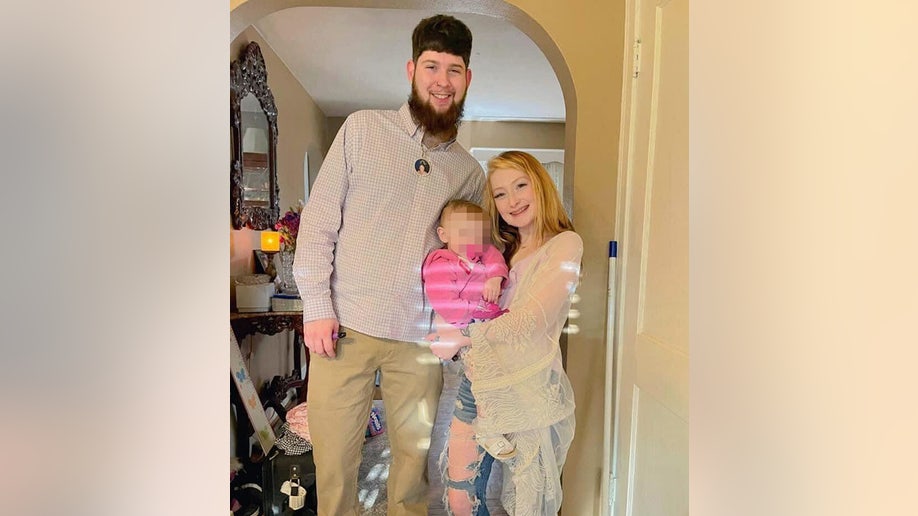 Kaitlynn Lee on the right holds her child in a pink shirt while Joshua Thompson smiles on the left