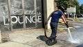 A firefighter cleans blood stains off the sidewalk outside a nightclub in Birmingham, Ala. on Sunday, Sept. 22, after a mass shooting took place. - Fox News