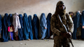 A Taliban fighter stands guard as women wait to receive food rations distributed by a humanitarian aid group in Kabul, Afghanistan, Tuesday, May 23, 2023. - Fox News