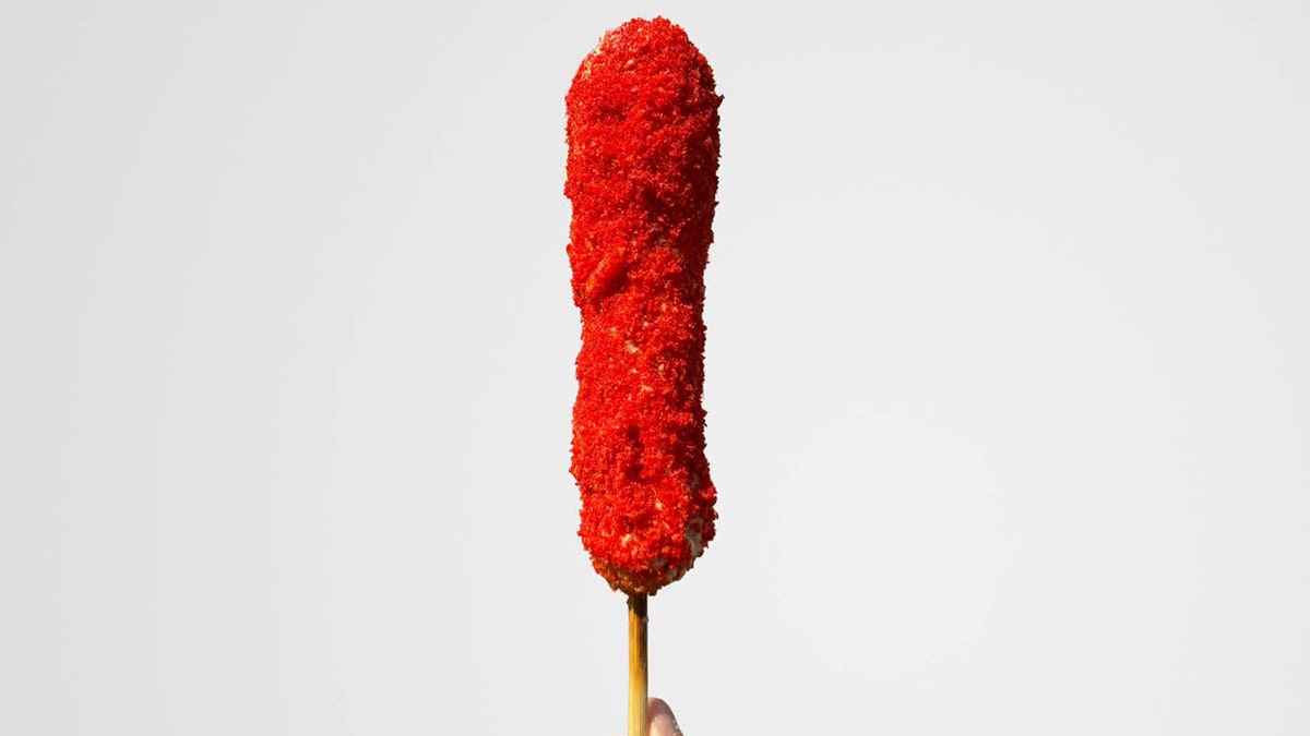 Korean corn dog coated in Hot Cheetos.