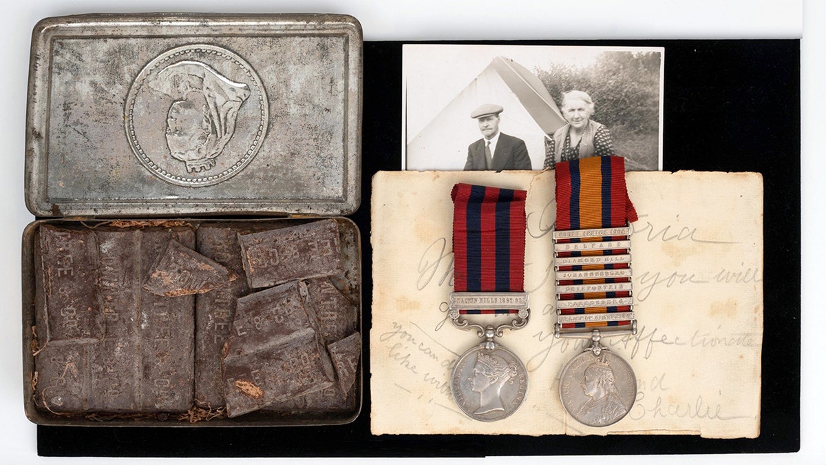 An auction batch  featuring medals, a letter, and a precise  aged  container  of chocolate. 