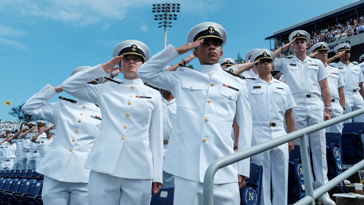 Aspirantes fazem uma saudação durante a cerimônia de comissionamento e formatura na Academia Naval dos EUA em Annapolis, Maryland, em 24 de maio de 2024.