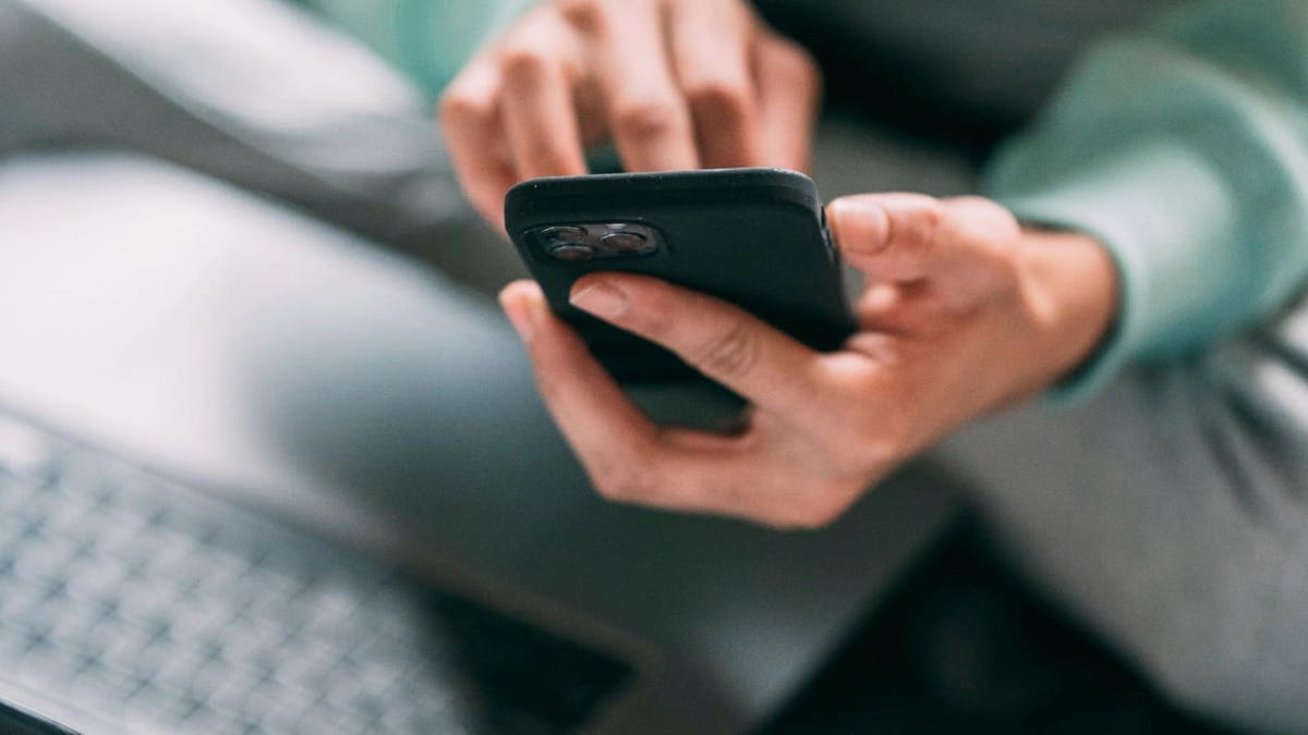 Un hombre escribiendo en su teléfono 